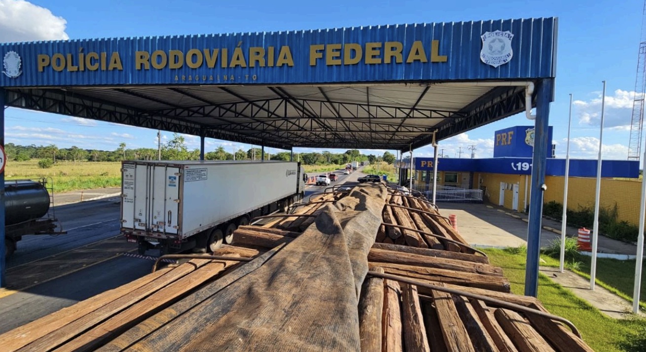 Imagem institucional da Polícia Rodoviária Federal (PRF) mostrando uma carreta carregada com madeira