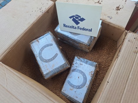 Caixa de papelão contaminada com tabletes de cocaína. 