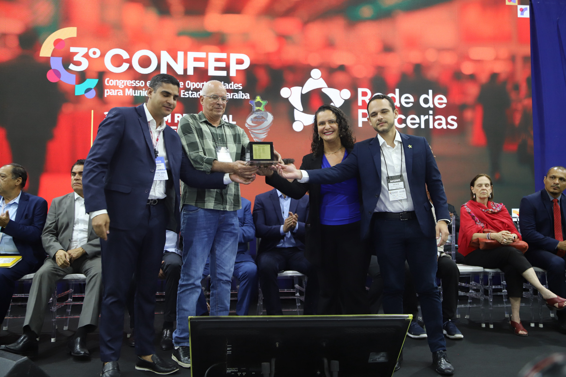 Foto da entrega do troféu da Rede de Parcerias a um representante do estado da Paraíba