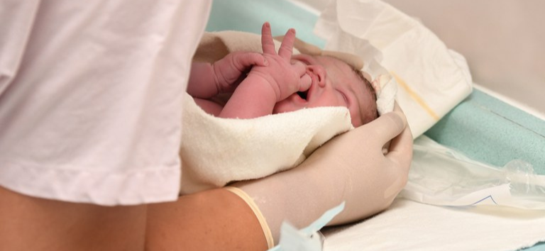 Enfermeira cuidando do bebê recém-nascido após o parto