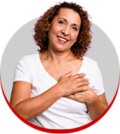 mulher sorrindo, com a mão sobre o peito, em gesto de cuidado com a saúde da mama