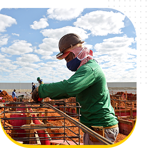 Trabalhador manuseando barras de ferro em uma obra de construção de uma Unidade de Pronto Atendimento (UPA).