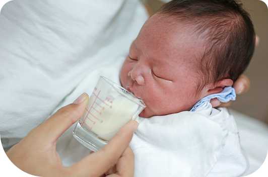 Foto de bebê tomando leite doado