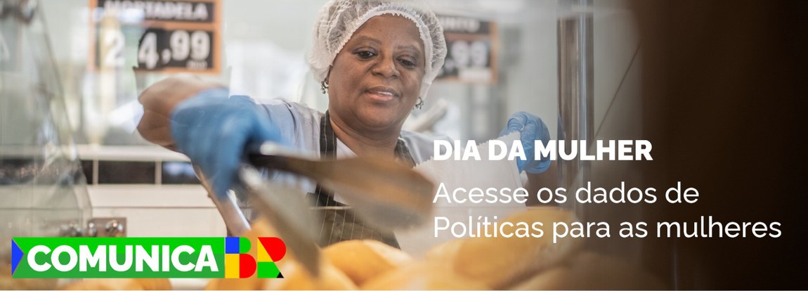 Mulher de touca, avental e luvas enchendo uma sacola com pães numa padaria