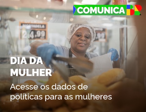 Mulher de touca, avental e luvas enchendo uma sacola com pães numa padaria