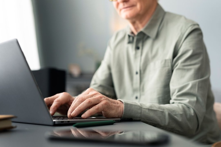 senior-man-is-using-laptop-sitting-desk-living-room.jpg