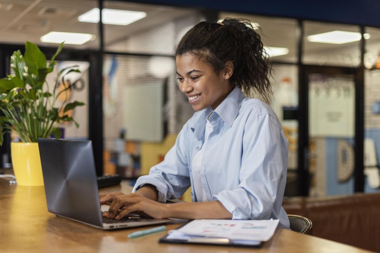 side-view-smiley-woman-working-with-laptop-office.jpg