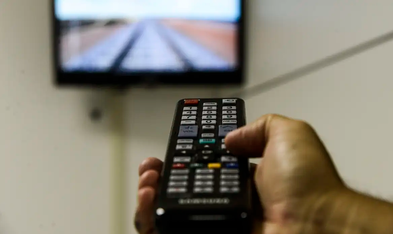 Pessoa com controle remoto na mão