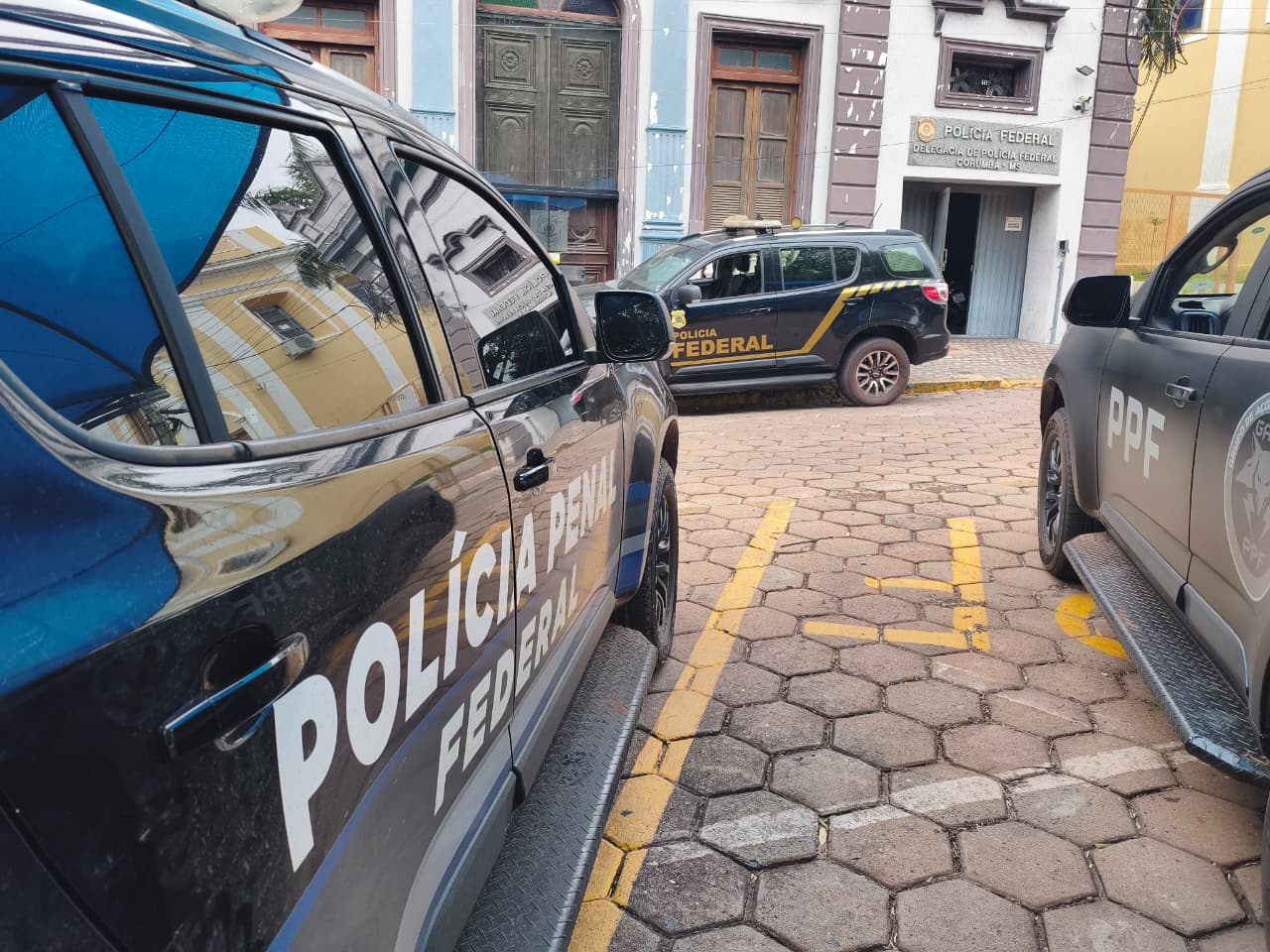 Imagens de três carros com identificação da Policia Penal Federal e Policia Federal.
