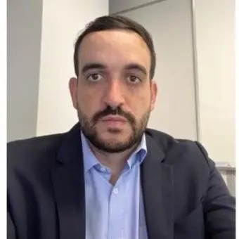 Homem branco, calvo, usando terno preto e camisa azul clara, com o texto Fernando André Santana de Souza