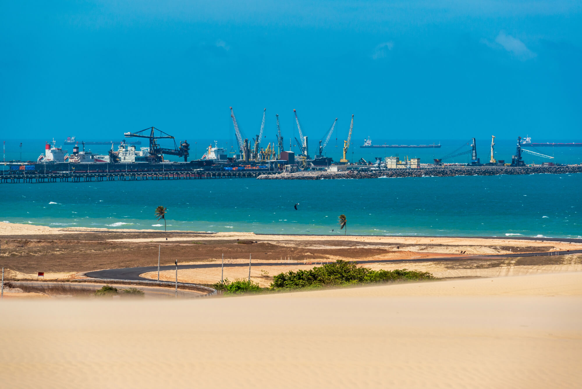 Foto exibindo o porto de Pecém no horizonte da costa