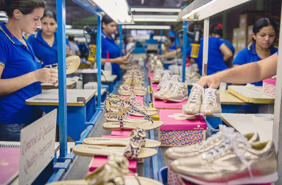 Imagem de uma linha de produção de sandálias e tênis.