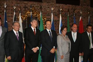 Seis pessoas de pé, uma ao lado da outra, pousando sorridentes para a foto. 