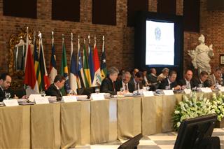 Várias pessoas sentadas atrás de uma bancada.