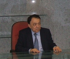 Paes Landim sentado numa mesa.