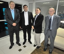 Quatro homens de pé pousando para a foto.