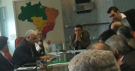 Várias pessoas sentadas numa mesa e conversando entre si.