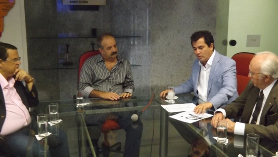 Superintendente da Sudene Zé Márcio e o Secretário de Turismo do Rio Grande do Norte Ruy Gaspar conversam com mais duas pessoas. Todos estão sentados numa mesa.