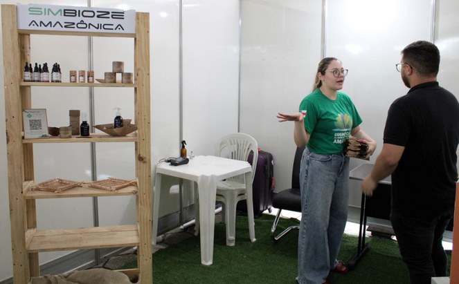 Foto mostra mulher de blusa verde fazendo apresentação