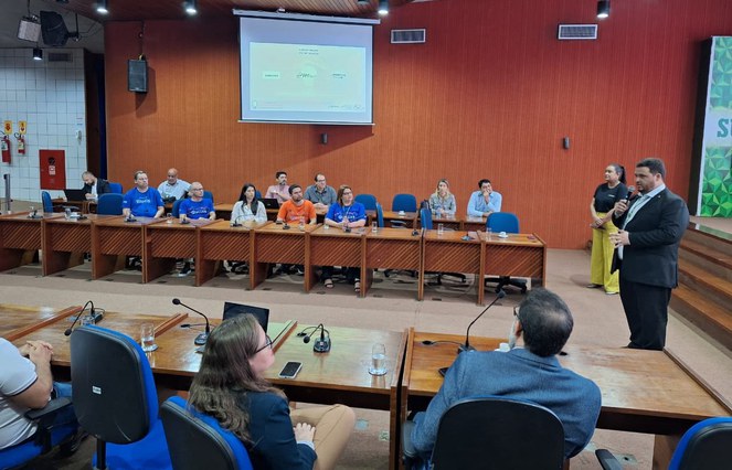 Foto mostra homem em pé falando num evento