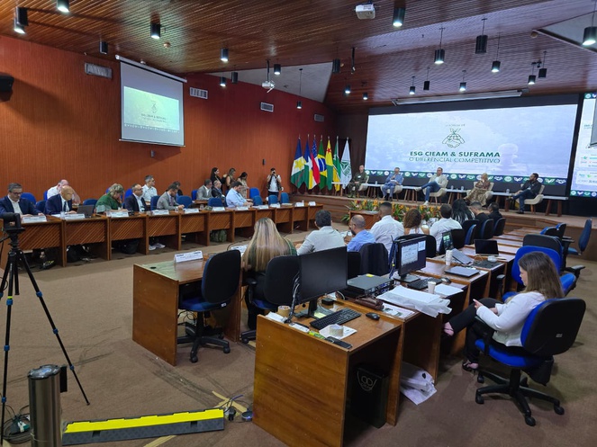 Foto mostra auditório cheio e um telão ao fundo