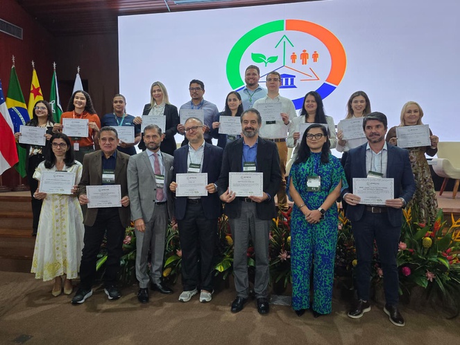 Foto mostra pessoas agrupadas segurando certificados