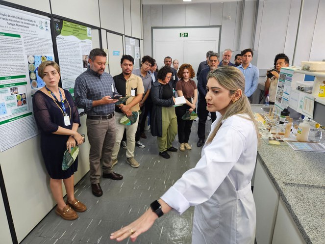 Foto mostra a servidora do CBA, que está de jaleo branco, mostrando projetos em execução no Centro