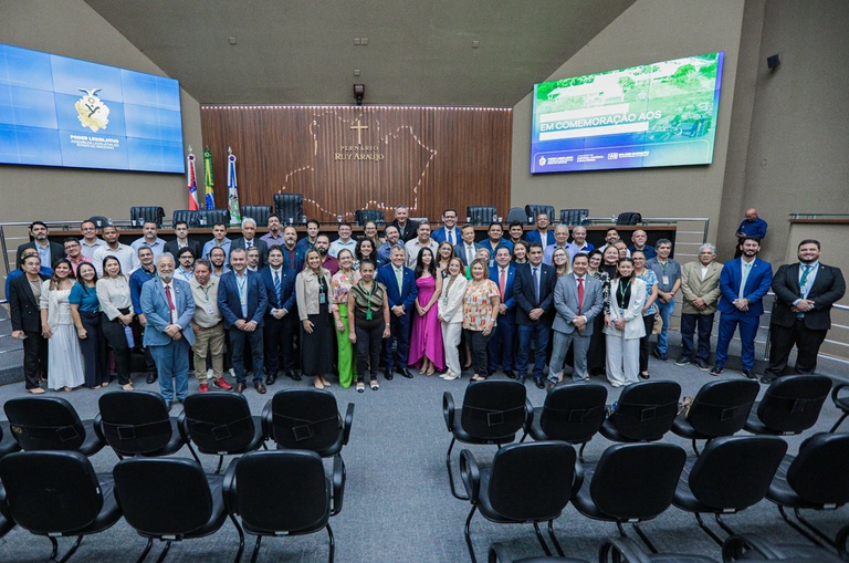 Foto mostra pessoas agrupadas para tirar uma foto em um auditório