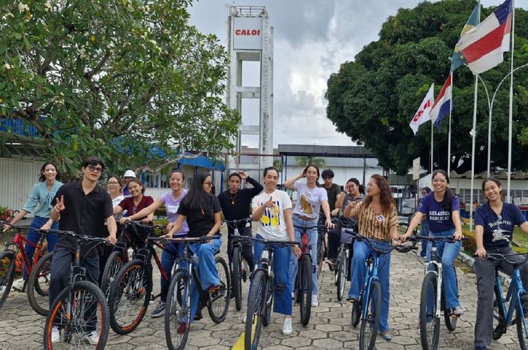 Foto mostra grupo de jovens posando para sessão de fotos em cima de bicicletas