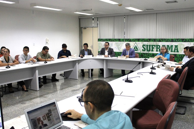 Foto mostras pessoas em uma reunião institucional