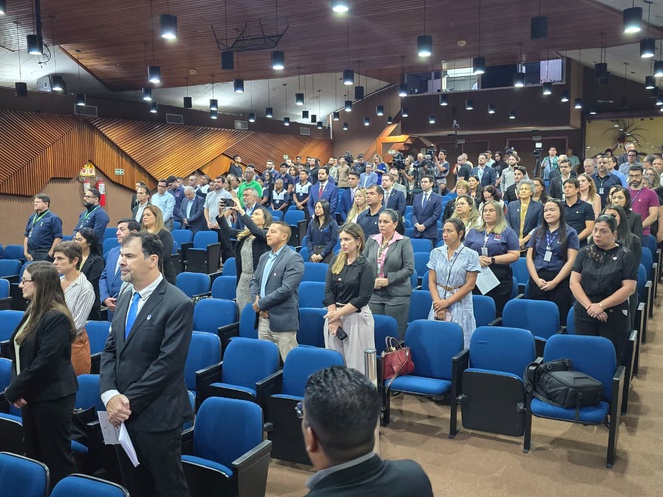 Foto mostra pessoas dentro de um auditório quase que lotado