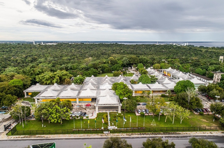 Foto mostra um imóvel do alto, além de floresta e rio