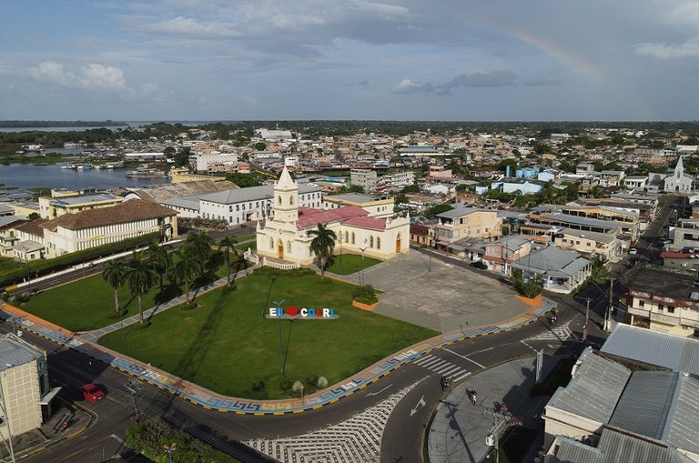 Foto mostra uma imagem aérea de uma cidade, com imóveis e um rio