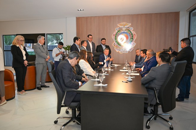 Foto mostra homem gesticulando em reunião com grupo de pessoas