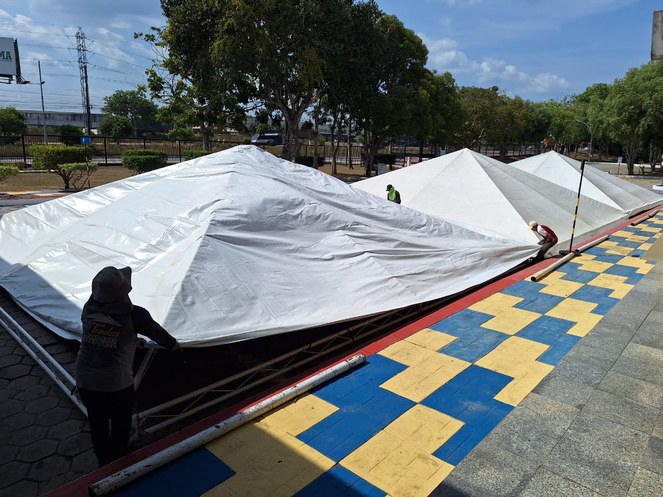 Foto mostra homens erguendo tendas
