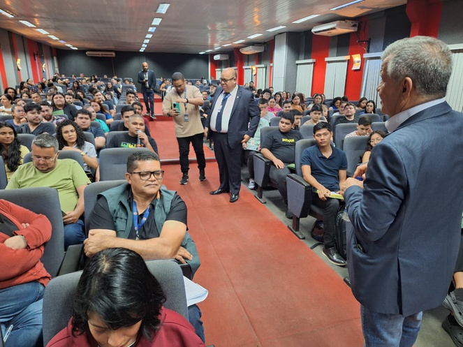 Foto mostra várias pessoas em um auditório lotado