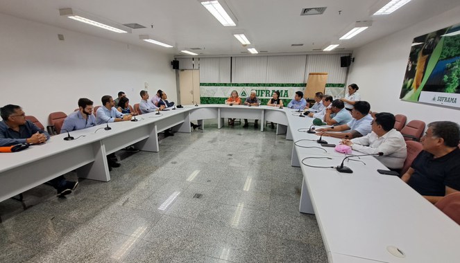 Foto mostra um grupo de pessoas numa reunião