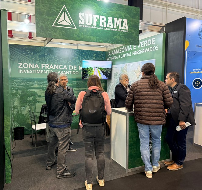 Foto mostra grupo de pessoas pegando informações em um estande com o nome Suframa