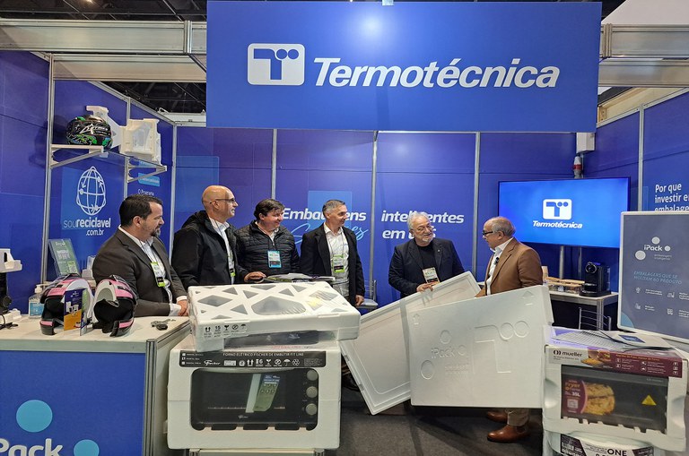 Foto mostra homem segurando isopor diante de outros homens