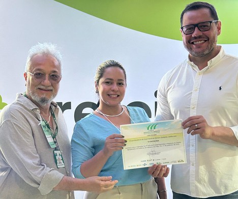 Foto mostra mulher e dois homens segurando um certificado