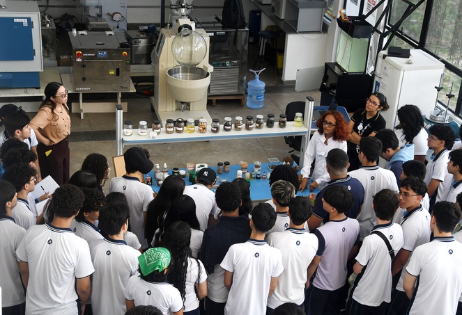 Foto mostra pessoas visitando um laboratório