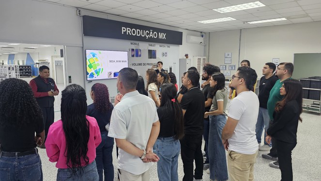 Foto mostra grupo de pessoas em visita a uma empresa