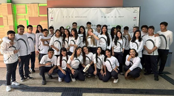 Foto mostra grupo de alunos de blusa branca posando para sessão de foto
