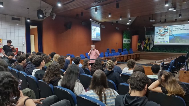 Foto mostra homem em pé falando ao microfone