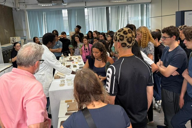 Foto mostra homem de jaleco branco apresentando alguns experimentos científicos