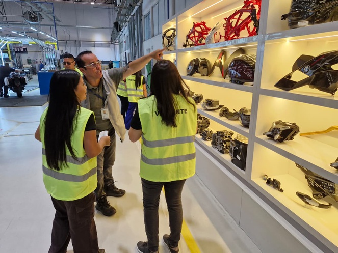 Foto mostra homem apontando para prateleiras com equipamentos automotivos