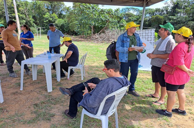 Foto mostra pessoas em uma tenda prestando esclarecimentos sobre determinada atividade