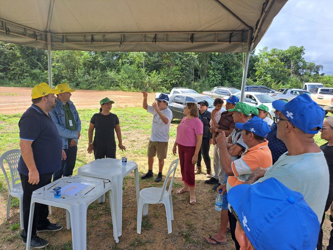 Foto mostra pessoas em uma tenda prestando esclarecimentos sobre determinada atividade a outro grupo de pessoas