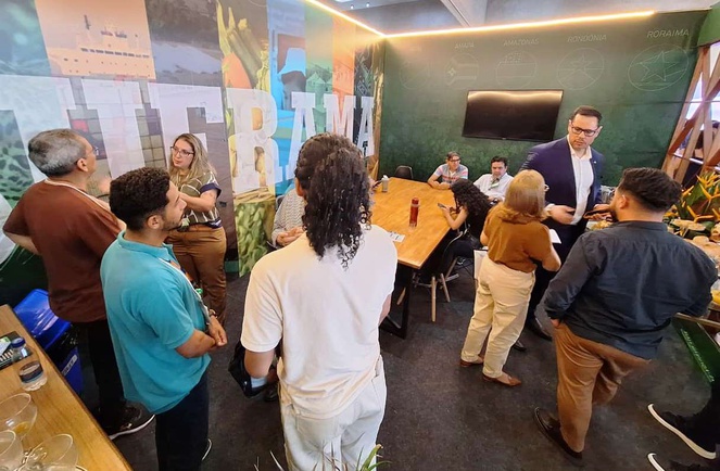 Foto mostra pessoas reunidas num estande de uma feira de tecnologia