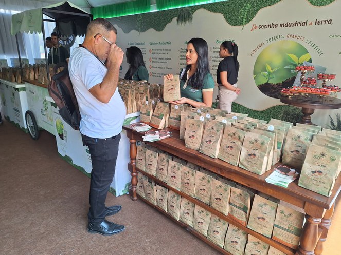 Foto mostra mulher apresentando sacola a homem